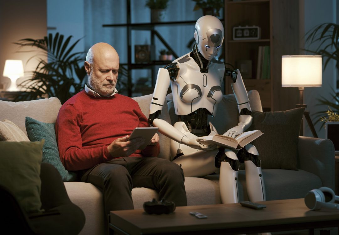 Humanoid AI robot and senior man sitting on the couch and spending time together: the man is using a tablet and the robot is reading a book